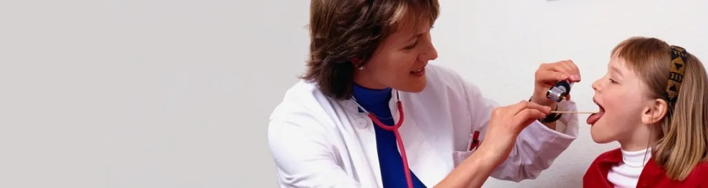 Doctor checking child's throat.